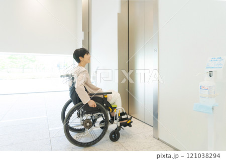 エレベーターに乗ろうとする車椅子の女性 エレベーターに乗ろうとする車椅子の女性 121038294
