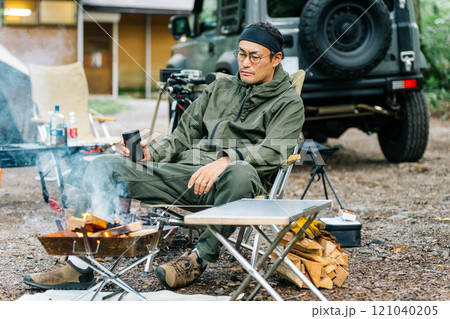 キャンプ場で焚き火する男性キャンパー（焚き火台・ソロキャンプ・ソロキャン） 121040205