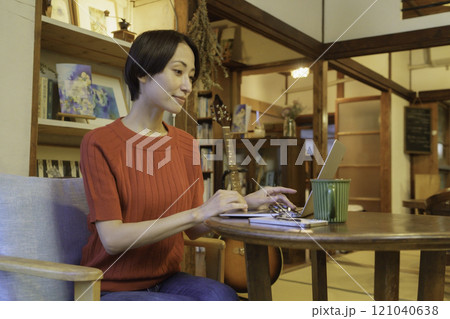古民家カフェでパソコン作業をするミドルエイジの女性 121040638