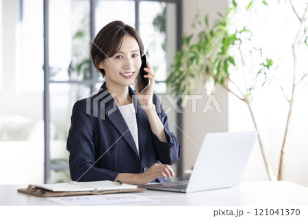 ビジネス スマホで通話しているビジネスウーマン ビジネス スマホで通話しているビジネスウーマン 121041370