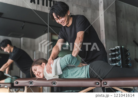 マッサージをするスポーツ整体師・スポーツトレーナーの男性 マッサージをするスポーツ整体師・スポーツトレーナーの男性 121041614