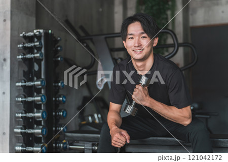 スポーツジムでダンベル・鉄アレイを使って腕を鍛える筋トレをするアジア人男性 スポーツジムでダンベル・鉄アレイを使って腕を鍛える筋トレをするアジア人男性 121042172