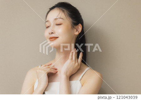 顔に手を当てて微笑む女性 顔に手を当てて微笑む女性 121043039