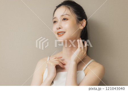 顔に手を当てて微笑む女性 121043040