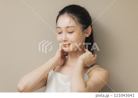 顔に手を当てて微笑む女性 顔に手を当てて微笑む女性 121043041
