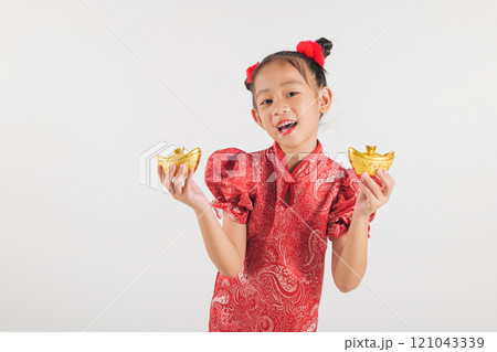 Happy Chinese New Year Smiling Asian girl wearing a red cheongsam dress holds a gold ingot, symbolizing wealth and prosperity. Isolated on a white background, festive and traditional Happy Chinese New Year Smiling Asian girl wearing a red cheongsam dress holds a gold ingot, symbolizing wealth and prosperity. Isolated on a white background, festive and traditional 121043339
