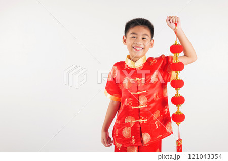 Chinese New Year. Happy Asian Chinese little kid boy smile wearing red cheongsam qipao holding silk lanterns on hand, Portrait children in traditional dress, studio short isolated on white 121043354