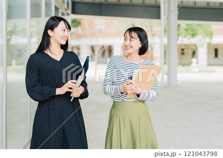 キャンパスで談笑する女子大学生 キャンパスで談笑する女子大学生 121043798