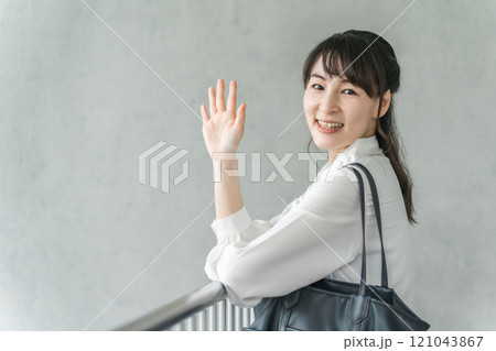 屋内の手すりで挨拶をするビジネスウーマン(おはよう) 屋内の手すりで挨拶をするビジネスウーマン(おはよう) 121043867