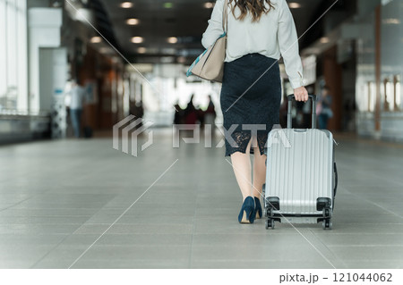 駅でスーツケースを持った出張・旅行帰りの女性・ビジネスウーマンの足元 駅でスーツケースを持った出張・旅行帰りの女性・ビジネスウーマンの足元 121044062