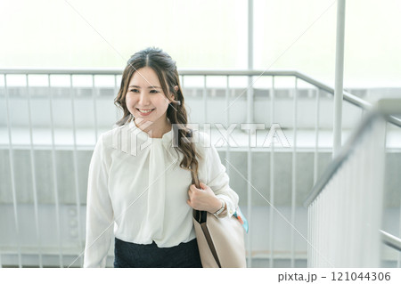 オフィスの階段を登る女性・ビジネスウーマン（朝・出社・出勤・通勤） 121044306