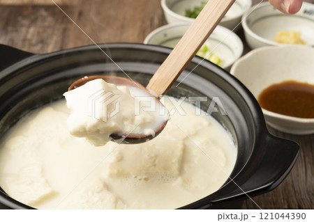 温泉豆腐 湯豆腐 土鍋で煮た豆腐をおたまですくう 温泉豆腐 湯豆腐 土鍋で煮た豆腐をおたまですくう 121044390