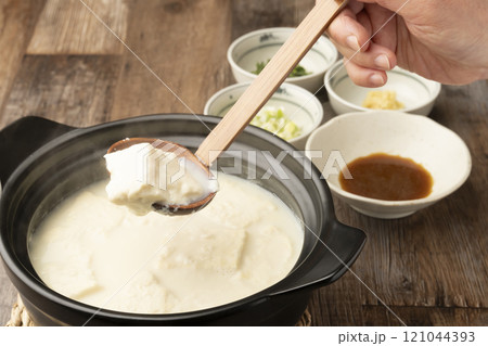 温泉豆腐 湯豆腐 土鍋で煮た豆腐をおたまですくう 温泉豆腐 湯豆腐 土鍋で煮た豆腐をおたまですくう 121044393