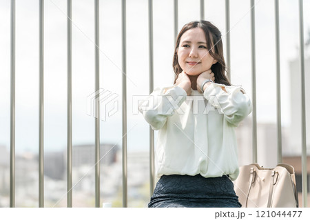 日焼け止め・制汗剤を首に塗る若いアジア人ビジネスウーマン（紫外線対策・デオドラント・スキンケア） 121044477