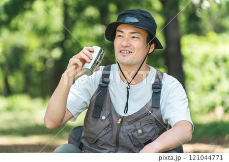 キャンプ場でキャンプ・グランピングを楽しむ男性(水・コーヒー・ビールをを飲む) キャンプ場でキャンプ・グランピングを楽しむ男性(水・コーヒー・ビールをを飲む) 121044771