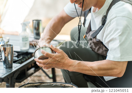 ソロキャンプで後片付けする男性キャンパー 121045051