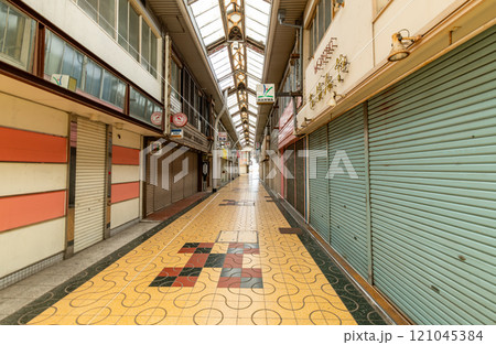 シャッターが下り閑散とした無人の商店街 121045384