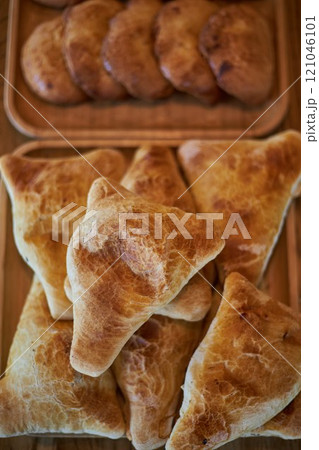 Fresh pastries on wooden plates: triangular samosas samosas with meat, sochen 121046101