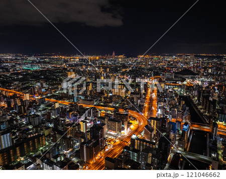 Vibrant city life in Osaka, Japan, a high vantage view of illuminated buildings and bustling roads at night captures the city's energetic spirit 121046662