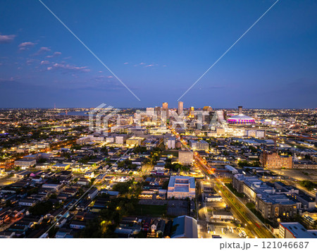 Aerial view of New Orleans skyline illuminating at dusk, showcasing vibrant city lights, prominent buildings, and the iconic Caesar Superdome under a beautiful twilight sky 121046687