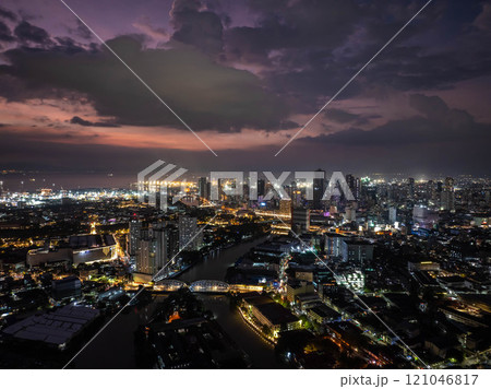 Manila's city lights shimmering at dusk, forming a stunning vista beneath a dramatic sky, displaying lively urban scenery from an elevated perspective Manila's city lights shimmering at dusk, forming a stunning vista beneath a dramatic sky, displaying lively urban scenery from an elevated perspective 121046817
