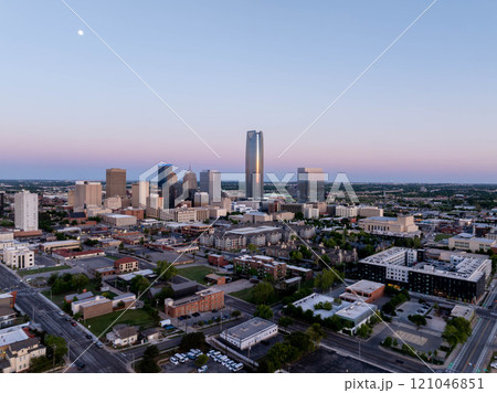 Stunning aerial sunrise view of Oklahoma City skyline with Devon Energy Center standing tall and visible moon, highlighting urban landscape and architectural marvels Stunning aerial sunrise view of Oklahoma City skyline with Devon Energy Center standing tall and visible moon, highlighting urban landscape and architectural marvels 121046851