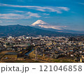 Majestic Mount Fuji overlooks a vibrant Japanese city, showcasing the perfect harmony of nature and urban development beneath a clear blue sky 121046858
