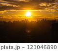 Glowing sunset casting stunning silhouette of Manila city skyline against golden clouds, showcasing the urban landscape 121046890