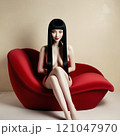 紅い唇型ソファーに座るセクシーな黒髪美女 121047970