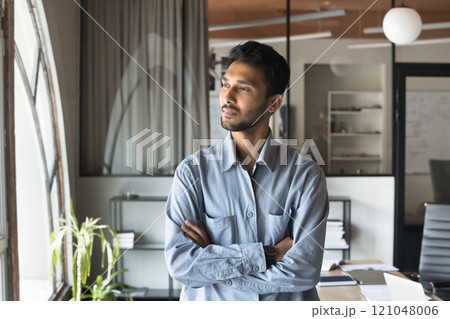 Indian business man standing with arms crossed with thoughtful expression Indian business man standing with arms crossed with thoughtful expression 121048006