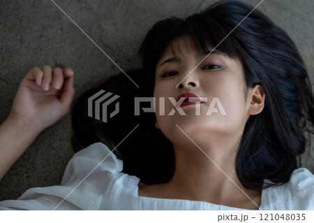 フローリングに寝転ぶ若い女性 フローリングに寝転ぶ若い女性 121048035