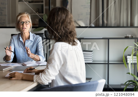 Middle-aged businesslady hold meeting with shareholders in boardroom Middle-aged businesslady hold meeting with shareholders in boardroom 121048094