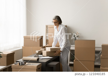 Serious mature businesswoman engaged in Internet store management 121048185