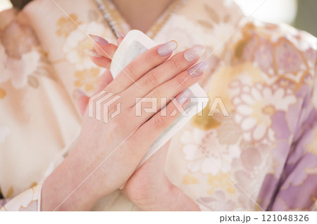 かじかんだ手をカイロで温める着物姿の若い女性手元 かじかんだ手をカイロで温める着物姿の若い女性手元 121048326