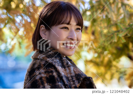 紅葉狩りを楽しむショートボブの若い女性 121048402