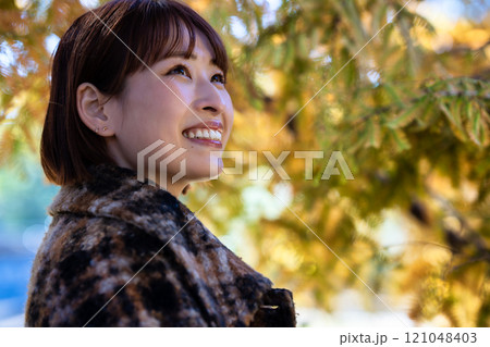 紅葉狩りを楽しむショートボブの若い女性 121048403