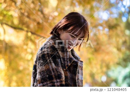 紅葉狩りを楽しむショートボブの若い女性 121048405
