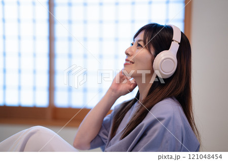 和室で音楽を聴くミドルの女性 121048454