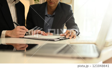 Cropped shot financial advisor pointing at reports planning investment project with client Cropped shot financial advisor pointing at reports planning investment project with client 121048641