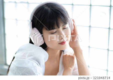 ヘッドホンで音楽を聴く若い女性 ヘッドホンで音楽を聴く若い女性 121048714