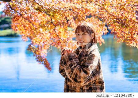 紅葉狩りを楽しむショートボブの若い女性 121048807