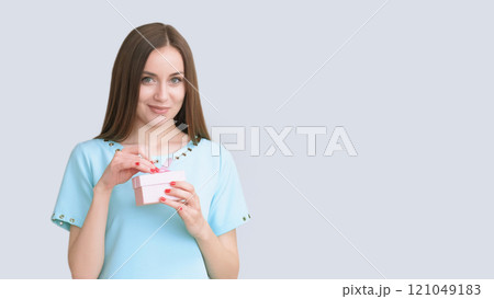 Party fun. Festive joy. Smiling satisfied beautiful happy woman in blue with present in box isolated on light copy space background. Party fun. Festive joy. Smiling satisfied beautiful happy woman in blue with present in box isolated on light copy space background. 121049183