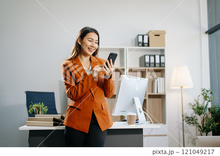 Confident business expert attractive smiling young woman holding digital tablet  on desk in creative 121049217