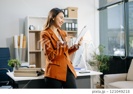 Confident business expert attractive smiling young woman holding digital tablet  on desk in creative 121049218