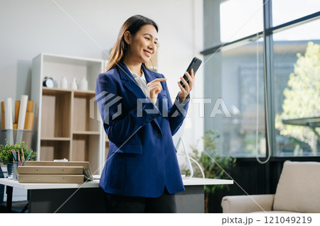 Confident business expert attractive smiling young woman holding digital tablet  on desk in creative 121049219