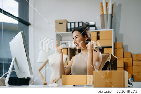 Young business owner woman prepare parcel box and standing check online orders for deliver Young business owner woman prepare parcel box and standing check online orders for deliver 121049273