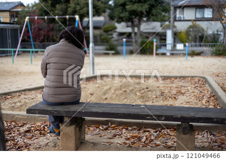 秋の公園で一人悩む中高年女性 121049466
