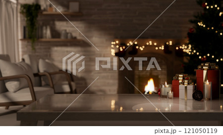 A coffee table in a cozy living room, illuminated by a glowing Christmas tree and a fireplace. 121050119