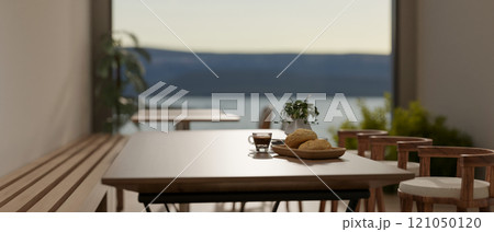 A close-up of a wooden table and stools in a cozy contemporary coffee shop. 121050120