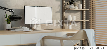 A modern, minimalist radio podcast office featuring a computer, a microphone, and decor. 121050121